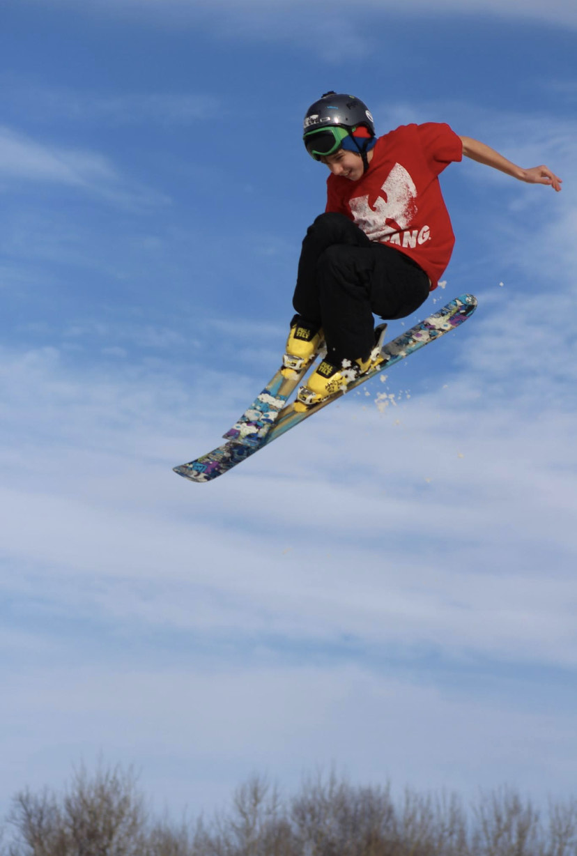 Teen performing a stunt ski jump